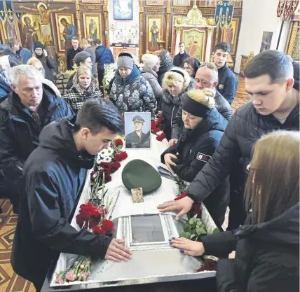  ?? ?? ↑ Relatives of Russian serviceman Nikita Avrov, 20, who was killed in Ukraine in March, at his funeral service