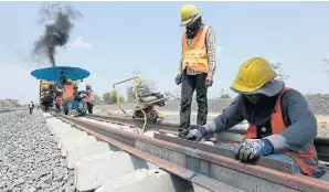  ?? PATIPAT JANTHONG ?? Workers on the double-track railway in Nakhon Ratchasima’s Muang district. The UTCC has urged the government to let smaller firms take part in infrastruc­ture projects.