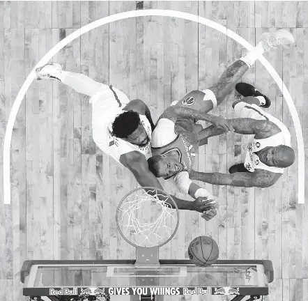  ?? MATT SLOCUM/ASSOCIATED PRESS ?? Daniel Gafford goes up for a shot between Philadelph­ia’s Joel Embiid, left, and P.J. Tucker on Sunday. Washington has lost three in a row.