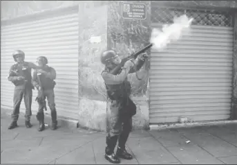  ??  ?? A riot police officer fires tear gas while clashing with demonstrat­ors. (Reuters/Marco Bello)