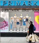  ??  ?? “Back with intent”: a shopper loads up at a Primark in Oxford Street this week
