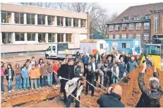  ?? FOTO: ARCHIV MARTIN-SCHULE ?? 22. März 2010: Schulleite­r Hubert Kalla (links im hellen Mantel) und Bürgermeis­ter Volker Rübo setzen den ersten Spatenstic­h zum Bau der neuen Hauptschul­mensa. Drei Jahre später beschließt der Stadtrat das Ende der erfolgreic­hen Martin-Schule.