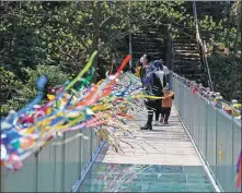  ?? ZHU LIXIN / CHINA DAILY ?? A tourist stops on a bridge to enjoy the scenery in Jingxian county, Anhui province on April 12. The bridge, built of steel and glass, is over a stream and leads to a mountain trail.