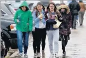  ?? Win McNamee Getty Images ?? STUDENTS at Great Mills High School in Maryland walk to meet their parents after the shooting.