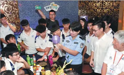  ?? QIAN WENPAN / FOR CHINA DAILY ?? A police officer teaches teenagers a lesson on keeping away from drugs at a karaoke bar in Guangzhou, Guangdong province, on Tuesday. She advised the teens to raise their awareness of drugs — even anesthetic­s such as nitrous oxide, or laughing gas —...