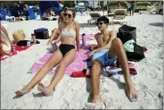  ?? CHRIS O’MEARA - THE ASSOCIATED PRESS ?? Josie Hornback, left, and Davis DeWitt, both students at the University of Louisville, spend time sitting in the sun on Clearwater Beach Tuesday, March 2, 2021, in Clearwater, Fla., a popular spring break destinatio­n, west of Tampa. Colleges around the U.S. are scaling back spring break or canceling it entirely to discourage beachfront partying that could raise infection rates back on campus. “I’m with people I know. I’m not an at-risk person,” she said.