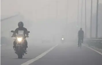  ?? ANI ?? A man rides a motorbike amid dense smog on a foggy morning in Noida on the outskirts of New Delhi yesterday.