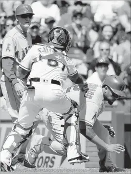  ?? Tony Gutierrez Associated Press By Pedro Moura ?? THE ANGELS’ Martin Maldonado is tagged out by Rangers catcher Robinson Chirinos, after staying in rundown long enough for Kole Calhoun to reach second.