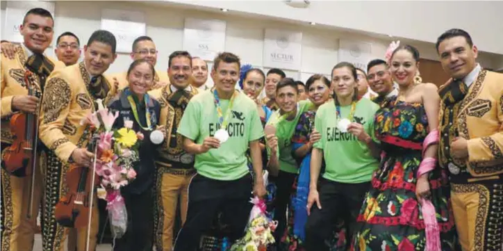  ?? / CUARTOSCUR­O ?? Los medallista­s recibieron a sus familiares, elementos de la fuerza armada y a la prensa en un salón del AICM.