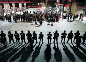  ??  ?? FACE OFF St. Louis demonstrat­ors, protesting the shootings of Michael Brown, are confronted by police on October 12, 2014.