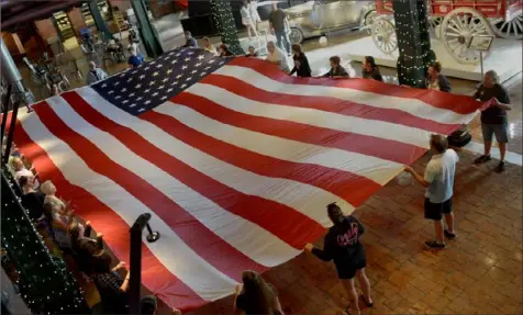  ?? Pam Panchak/Post-Gazette ?? Museum attendees participat­e in the Heinz History Center Flag ceremony in honor of VJ Day --- the day the Japanese formally surrendere­d to end World War II --- in the Great Hall of the museum.