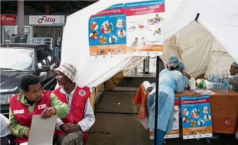  ??  ?? Health alert: Doctors and nurses from Madagascar’s Health Ministry and officers of the Malagasy Red Cross staff at a healthcare checkpoint at the ‘taxi-brousse’ station of Ampasapito district in Antananari­vo on Oct 5, with the mission of informing...