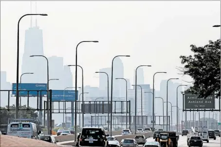  ?? ANTONIO PEREZ/CHICAGO TRIBUNE ?? Smog rises over the Chicago skyline on Thursday as vehicles move south along Interstate 90 at Fullerton.