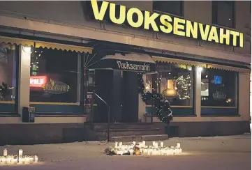  ?? — Reuters photo ?? Candles in front of the restaurant Vuoksenvah­ti where three women were killed in a shooting incident in Imatra, Eastern Finland.