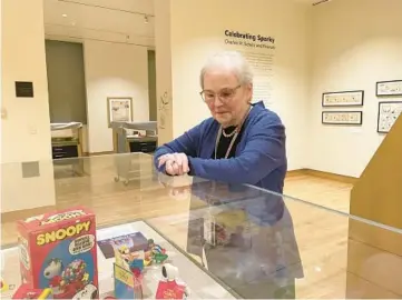  ?? PATRICK ORSAGOS/AP ?? Lucy Shelton Caswell, founding curator of the Billy Ireland Cartoon Library & Museum, examines memorabili­a tied to the comic strip “Peanuts” in Columbus, Ohio. Three exhibits in the U.S. are celebratin­g Charles M. Schulz’s birthday.