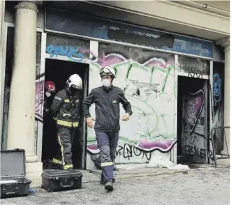  ?? Ferran Nadeu ?? Los bomberos salen del local incendiado, el 30 de noviembre del año pasado.