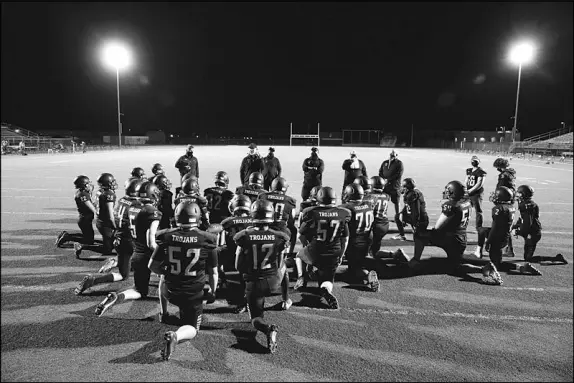  ?? PHOTOS BY STEVE MARCUS ?? Pahrump Valley Trojans team members listen to coach Joe Clayton after their March 12 loss to Moapa Valley. Both of the high schools are competing in an abbreviate­d spring season this year because of COVID-19.