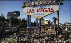  ??  ?? Flowers, candles and other items surround the famous Las Vegas sign at a makeshift memorial for victims of a mass shooting Monday in Las Vegas. Stephen Paddock opened fire on an outdoor country music concert killing dozens and injuring hundreds. AP...