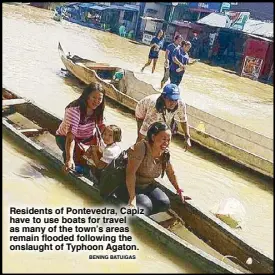  ?? BENING BATUIGAS ?? Residents of Pontevedra, Capiz have to use boats for travel as many of the town’s areas remain flooded following the onslaught of Typhoon Agaton.