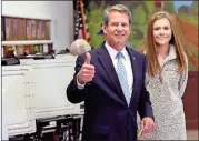  ?? / AP-John Bazemore ?? Republican Brian Kemp gives the thumbs up as he and youngest daughter Amy Porter leave after voting.