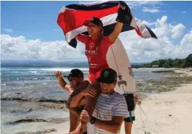  ?? WORLD SURF LEAGUE ?? Leilani McGonagle festejó con la bandera tica en los hombros de Anthony Fillingim y Noe Mar McGonagle.