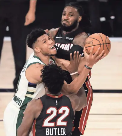  ?? GETTY IMAGES ?? Giannis Antetokoun­mpo drives as Miami’s Jimmy Butler and Jae Crowder defend.