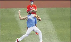  ?? MATT SLOCUM – THE ASSOCIATED PRESS ?? Phillies pitcher Jake Arrieta, front, throws in the outfield at Citizens Bank Park on Tuesday during the club’s summer training camp.