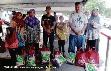  ??  ?? PENDUDUK bersama bantuan yang mereka terima.