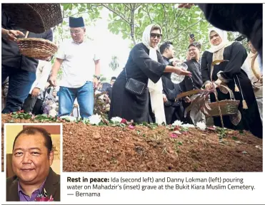  ?? — Bernama ?? Rest in peace: Ida (second left) and Danny Lokman (left) pouring water on Mahadzir’s (inset) grave at the Bukit Kiara Muslim Cemetery.
