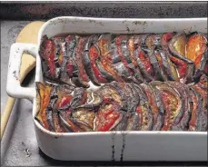  ?? E. JASON WAMBSGANS/CHICAGO TRIBUNE/TNS ?? Eggplants are sliced at regular intervals (but not all the way through), then tomato slices are sandwiched in. The finished dish can be served hot, cold or at room temperatur­e, making it flexible for summer entertaini­ng.