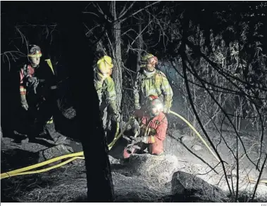  ?? EFE ?? Los bomberos de la UME realizan un arco nocturno en el área quemada en Santa Cruz del Valle (Ávila).