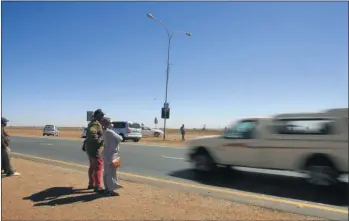  ?? PHOTO: JOHNNY ONVERWACHT ?? People wait for lifts at a hitchhikin­g spot near the N12/R28 intersecti­on in Westonaria, West Rand, where Issac Racodi and his girlfriend Mado Lephadi were stabbed to death in front of Racodi’s 9-year-old son.