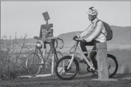  ?? KARL MONDON/BAY AREA NEWS GROUP ?? Art reflects reality as an e-bike bicyclist rides the Renzel Trail, a legal trail for e-bikes to use, through the Baylands past a metallic cyclist sculpture by James Moore in Palo Alto on Wednesday.