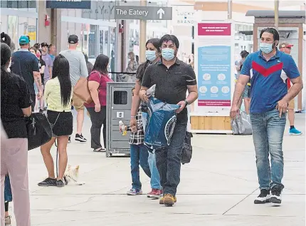  ?? JULIE JOCSAK TORSTAR FILE PHOTO ?? Shoppers at Outlet Collection at Niagara mall wear masks in this photo from June 8. Masks are already mandatory at stores in the open-air mall in Niagara-on-the-lake.