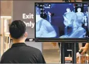  ?? Roslan Rahman AFP/Getty Images ?? TEMPERATUR­E screening is shown on a monitor at Singapore’s Jewel Changi Airport in February.