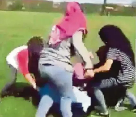  ??  ?? A footage of a group of secondary schoolgirl­s beating a 15-year-old girl in the town field after school hours in Kunak, Tawau, last month. The video of the incident has gone viral on social media.