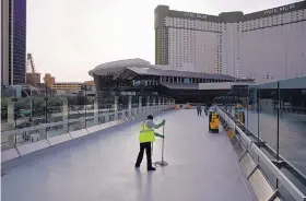  ?? JOHN LOCHER/ASSOCIATED PRESS ?? A worker cleans along the Strip in Las Vegas, Nevada, on March 31. The COVID-19 pandemic has been especially damaging to local economies that are heavily dependent on tourism, such as that of Las Vegas.