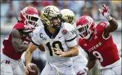  ?? COREY PERRINE/FLORIDA TIMES-UNION/AP ?? Wake Forest quarterbac­k Sam Hartman, who threw for three TDS, tries to outrun pressure from Rutgers during the Gator Bowl on Friday in Jacksonvil­le, Florida.