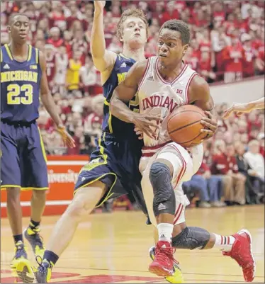  ?? | AP PHOTO ?? Indiana guard Yogi Ferrell (right) drives against Michigan guard Spike Albrecht on Sunday in Bloomingto­n.