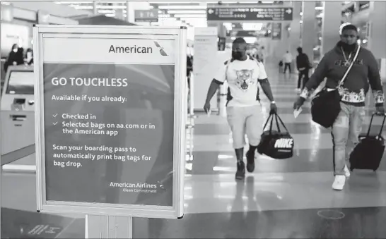  ?? JOHN J. KIM/CHICAGO TRIBUNE ?? A sign informs travelers of a touchless baggage check option at the American Airlines check-in area in Terminal 3 at O’Hare Internatio­nal Airport Thursday in Chicago.