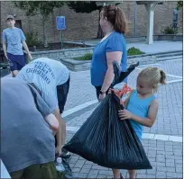  ?? SUBMITTED PHOTO — COURTESY OF BJ BREISH ?? Lansdale resident Addison Breish holds a bag of trash gathered during a cleanup event on Wednesday night, June 30, as William Curlett, left rear, and Deb Kline look on.