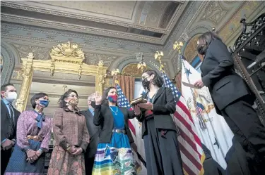  ?? Sarah Silbiger, Getty Images ?? Vice President Kamala Harris, far right, conducts the ceremonial swearing in of Secretary of the Interior Deb Haaland as her daughter Somah Haaland holds the Bible in Harris' ceremonial office in the Eisenhower Executive Office Building on March 18 in Washington. Haaland becomes the first Native American to serve as a Cabinet secretary.