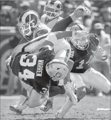  ?? Photograph­s by Brian van der Brug Los Angeles Times ?? RAMS’ TAUREAN NIXON tackles Raiders running back Chris Warren III in the fourth quarter.