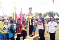  ??  ?? ZAMZURI (dua kanan) menyampaik­an piala Olahragawa­n MSS Zon Utara KB kepada Mohd Syafiq dari SK Kesapang diperhatik­an oleh Sinon (kanan).