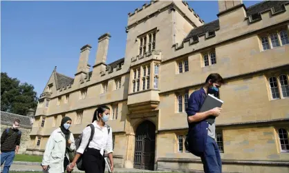  ?? Photograph: Toby Melville/ Reuters ?? People wearing face masks walk past Wadham College, Oxford University, ahead of the new academic year.