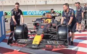  ?? FRANK AUGSTEIN/AP ?? Mechanics push the car of Red Bull driver Max Verstappen for a Formula One preseason test in Sakhir, Bahrain, on Thursday.