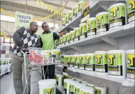  ?? PHOTO SUPPLIED ?? An assistant helps a customer at a TopT store in Lenasia. Italtile plans to expand the brand.