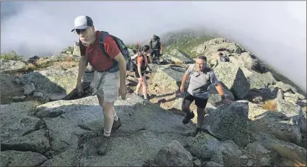  ?? Photograph­s by Ben Poston Los Angeles Times ?? SAM POSTON, left, hikes up Maine’s Mt. Katahdin, a 4,000-foot ascent and the northern terminus of the Appalachia­n Trail. In 1998, Sam and his son, Ben, started their quest to walk the 2,200 rugged miles that wind through 14 states from Georgia to Maine.