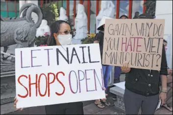  ?? Jae C. Hong File The Associated Press ?? Nail salon workers protesting in Westminste­r, Calif., will be back at work starting Friday after Gov. Gavin Newsom lifted restrictio­ns on salons, massage parlors and other businesses offering personal services.