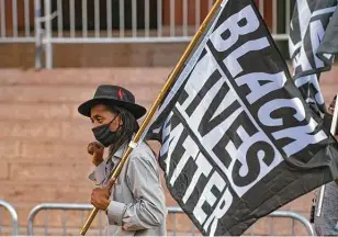  ?? Billy Calzada / Staff photograph­er ?? Pharaoh Clark carries a Black Lives Matter flag during a Young Ambitious Activists rally in downtown San Antonio on Friday.